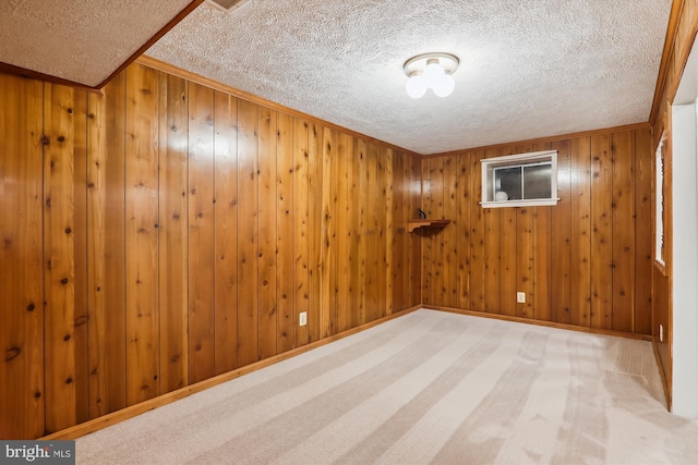 spare room with ornamental molding, light carpet, and a textured ceiling