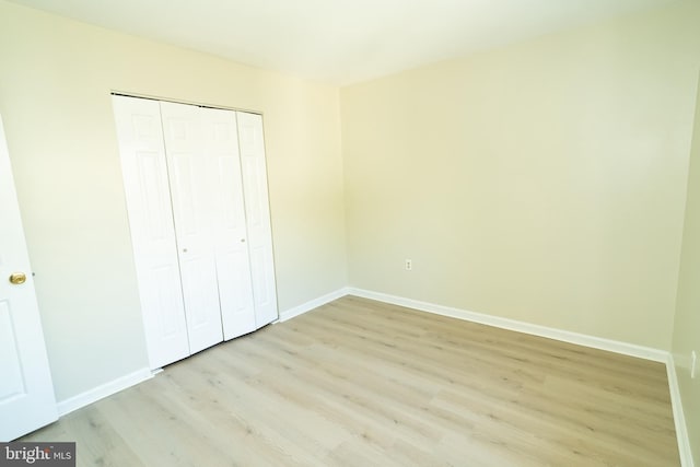 unfurnished bedroom with light hardwood / wood-style floors and a closet