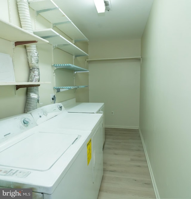 washroom with washer and clothes dryer and light hardwood / wood-style flooring