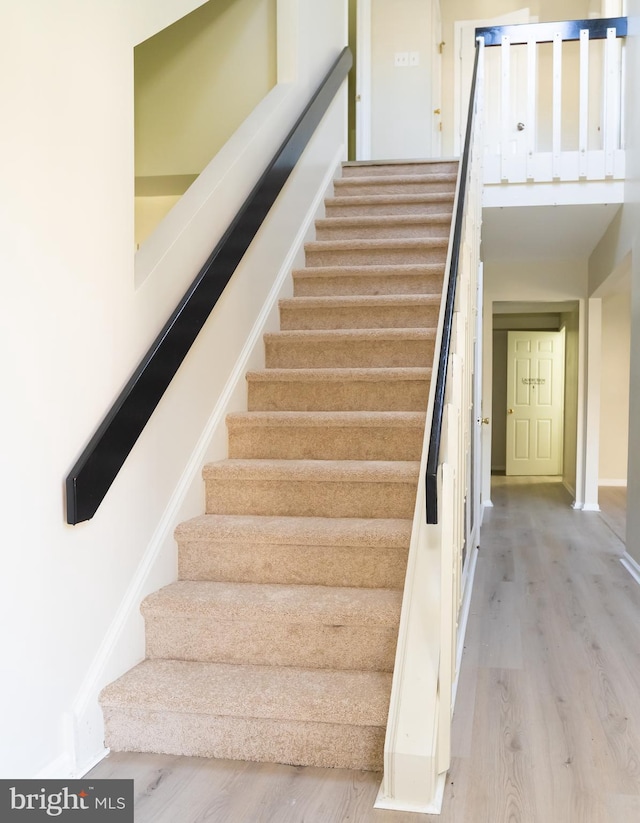 staircase with hardwood / wood-style floors