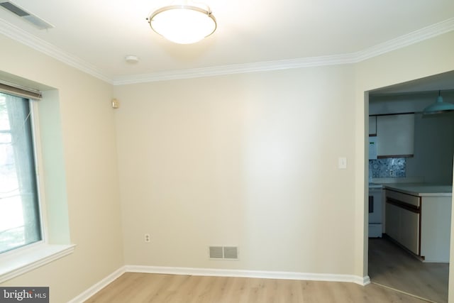 spare room with crown molding and light wood-type flooring