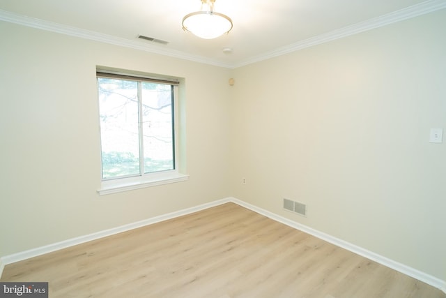 empty room featuring ornamental molding and light hardwood / wood-style flooring