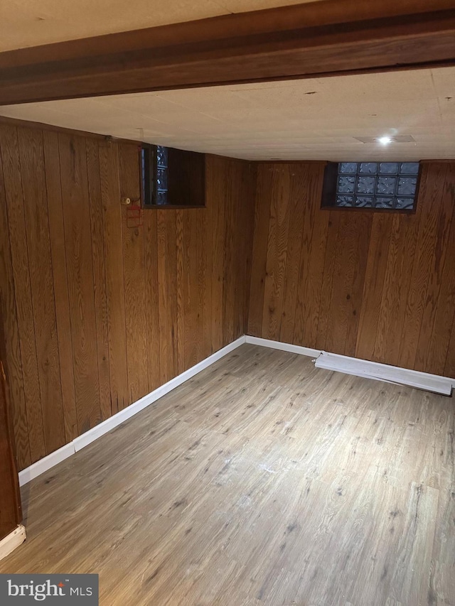 basement with hardwood / wood-style flooring and wood walls