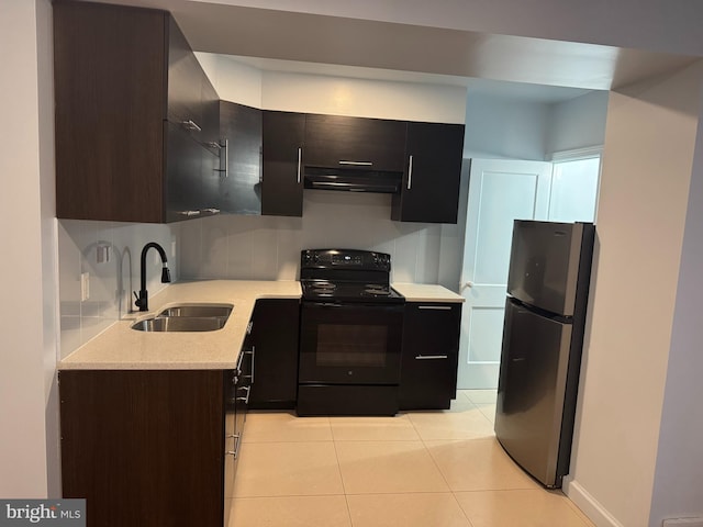 kitchen featuring sink, light tile patterned floors, stainless steel fridge, black electric range, and decorative backsplash