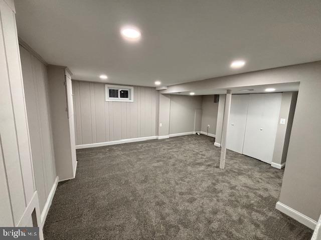 basement with dark colored carpet