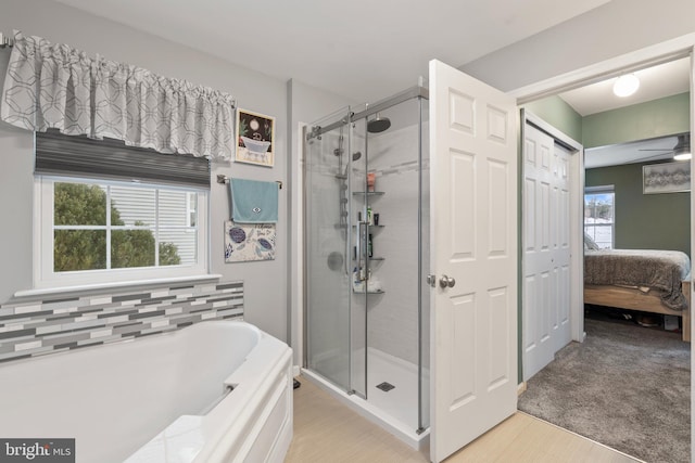 bathroom with independent shower and bath and ceiling fan