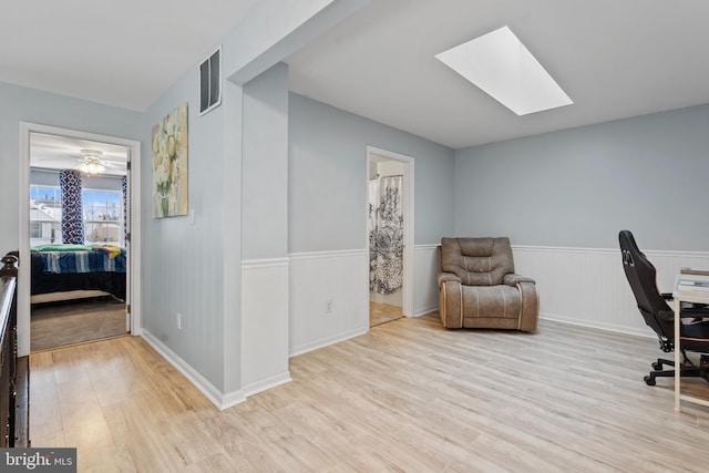 office featuring a skylight and light hardwood / wood-style floors