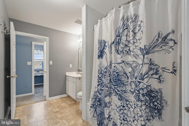 bathroom featuring vanity, curtained shower, and toilet