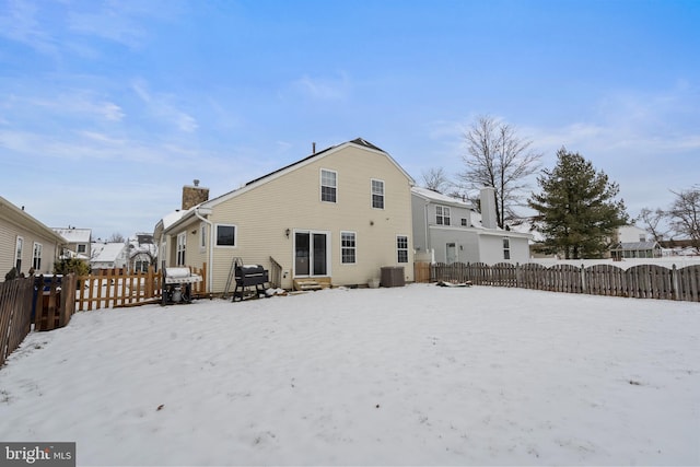 snow covered property with central air condition unit