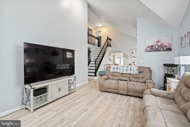 living room with high vaulted ceiling and light wood-type flooring