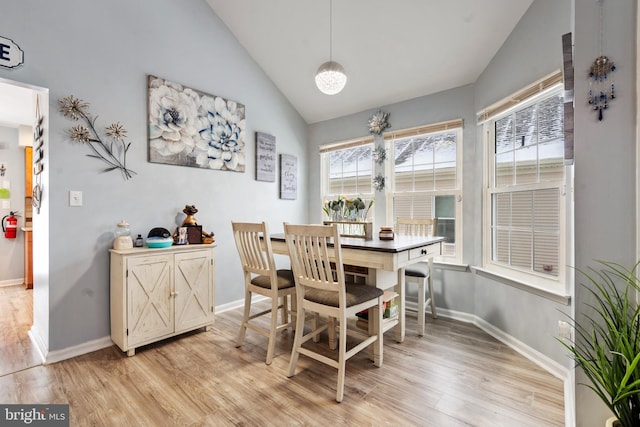 dining area with lofted ceiling and light hardwood / wood-style flooring