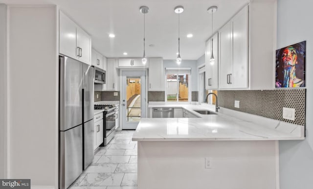 kitchen featuring appliances with stainless steel finishes, sink, white cabinets, and kitchen peninsula