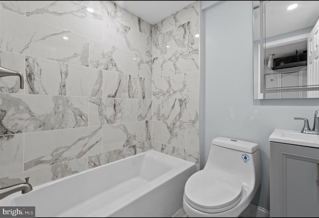 full bathroom featuring tiled shower / bath, vanity, and toilet