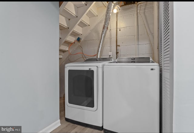 laundry area featuring washing machine and clothes dryer and light wood-type flooring