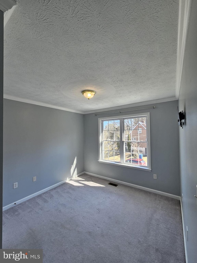 empty room with visible vents, crown molding, and baseboards