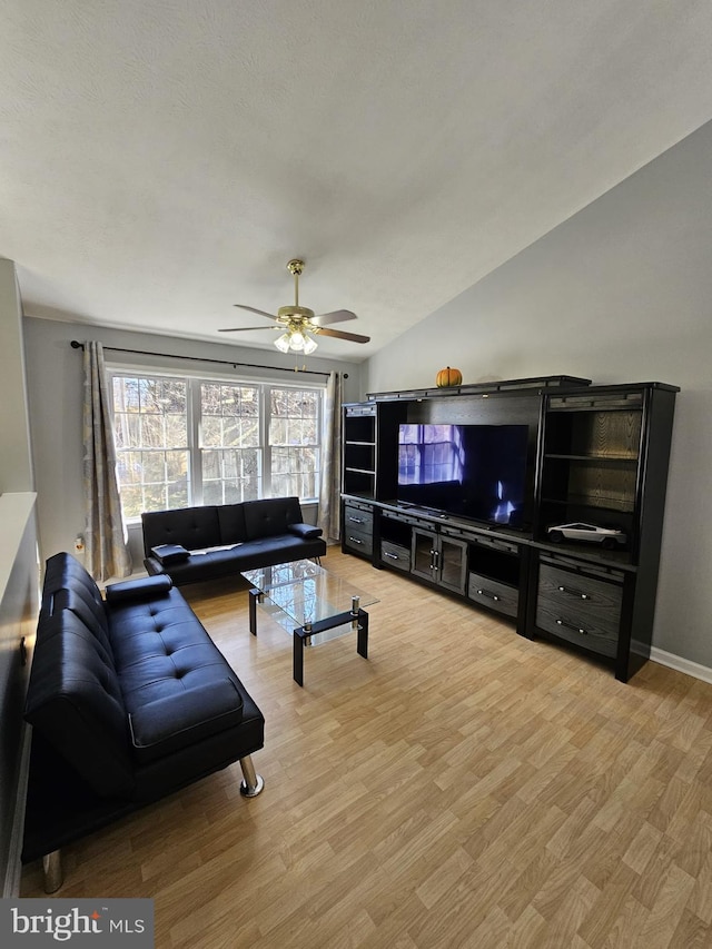 living area featuring lofted ceiling, baseboards, ceiling fan, and light wood finished floors