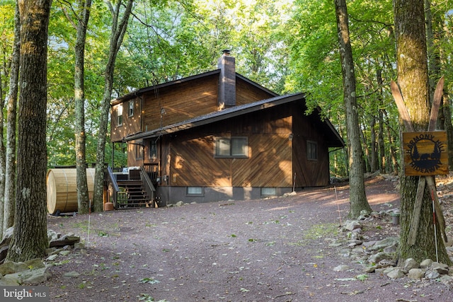 back of house with a storage unit