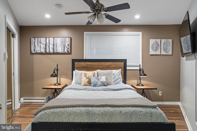 bedroom with baseboard heating, ceiling fan, and hardwood / wood-style floors