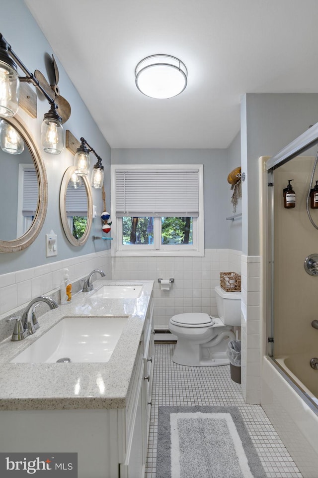 full bathroom with tile patterned flooring, combined bath / shower with glass door, tile walls, and toilet