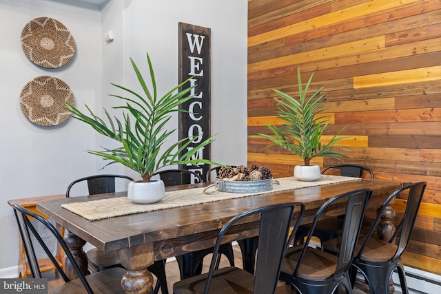 dining space featuring wood walls