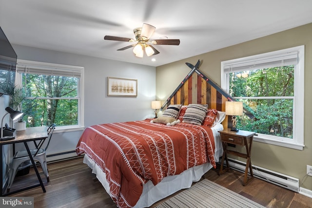 bedroom featuring baseboard heating, dark hardwood / wood-style flooring, and multiple windows