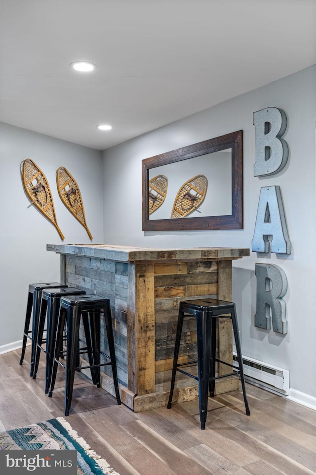 bar with a baseboard heating unit and hardwood / wood-style floors