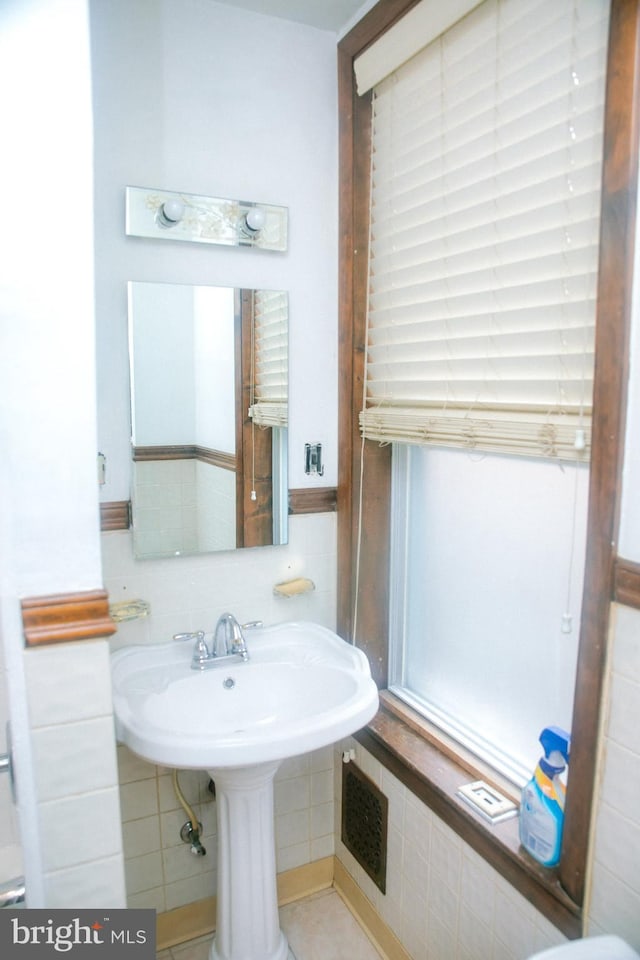 bathroom with sink and tile walls