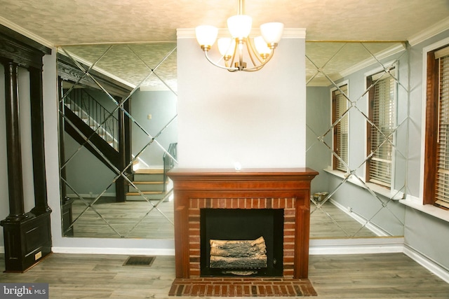 interior space featuring ornamental molding, a fireplace, a chandelier, and hardwood / wood-style floors