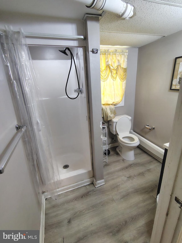 bathroom with wood-type flooring, toilet, and a shower with curtain