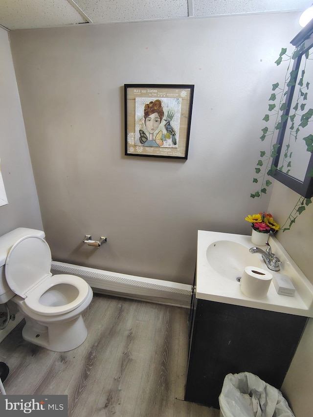 bathroom with vanity, hardwood / wood-style floors, toilet, and a drop ceiling