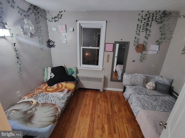 bedroom featuring hardwood / wood-style floors and radiator heating unit