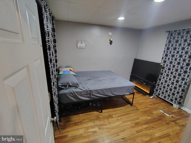 bedroom featuring hardwood / wood-style floors and a drop ceiling