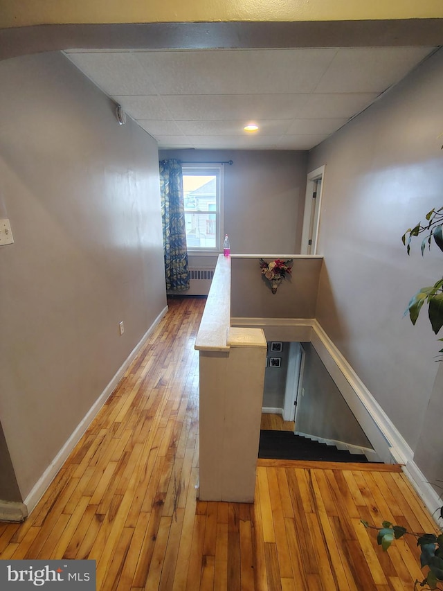 hallway with radiator heating unit and wood-type flooring