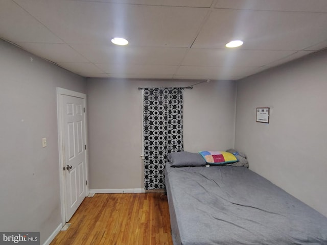 unfurnished bedroom with hardwood / wood-style flooring and a paneled ceiling