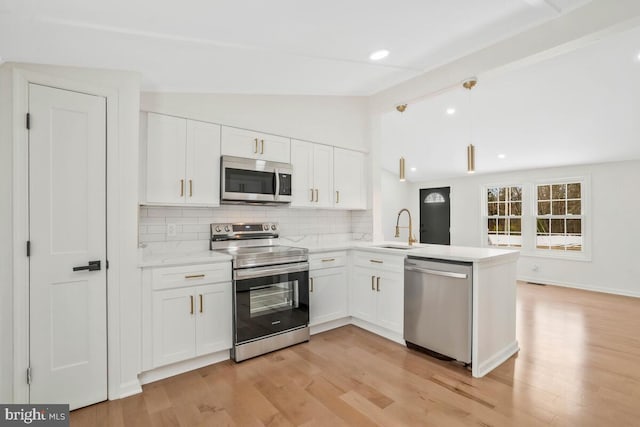 kitchen with sink, white cabinetry, decorative light fixtures, appliances with stainless steel finishes, and kitchen peninsula