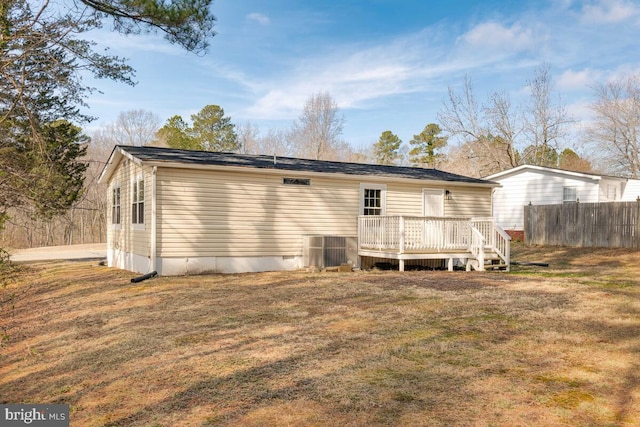 back of property featuring cooling unit, a lawn, and a deck