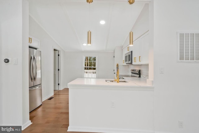 kitchen featuring appliances with stainless steel finishes, kitchen peninsula, sink, and white cabinets