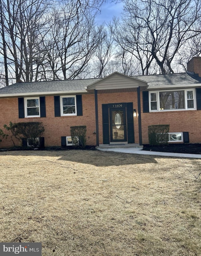 ranch-style home with ac unit, brick siding, and a chimney