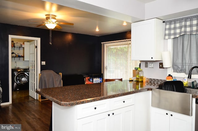 kitchen featuring dark stone countertops, white cabinetry, dark hardwood / wood-style flooring, washer / clothes dryer, and kitchen peninsula