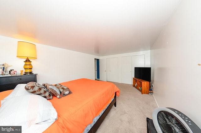 carpeted bedroom featuring two closets