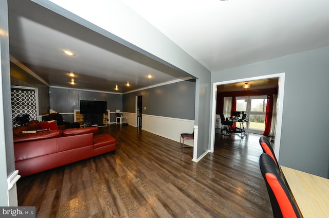 living room with dark wood-type flooring and crown molding