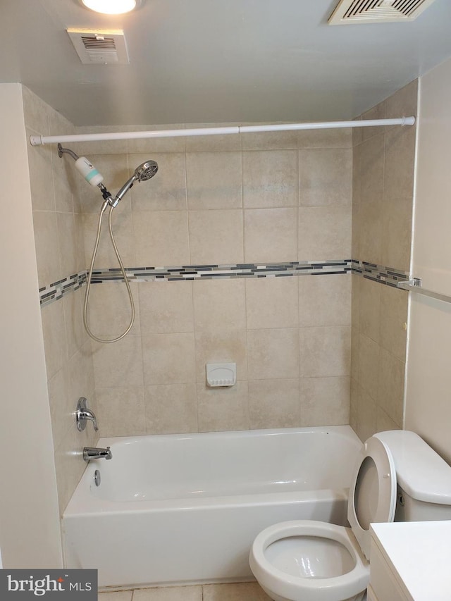 full bathroom featuring tiled shower / bath combo, vanity, and toilet