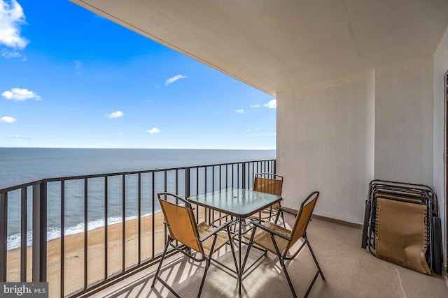 balcony featuring a water view and a view of the beach