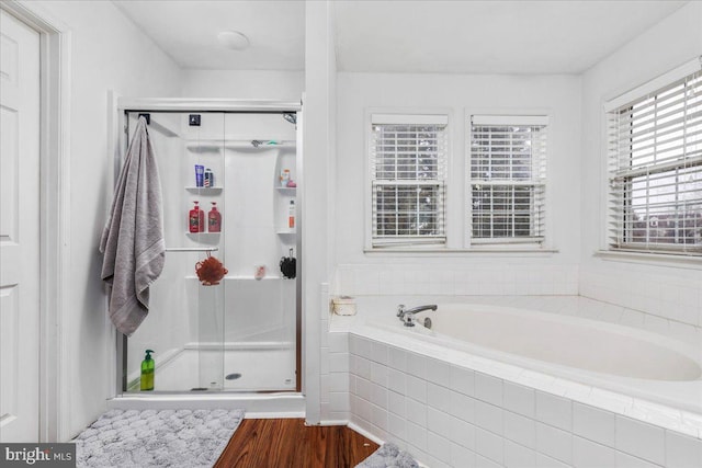 full bathroom featuring a garden tub, wood finished floors, and a shower stall