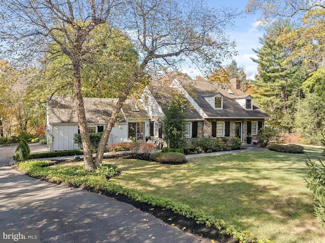 new england style home featuring a front lawn