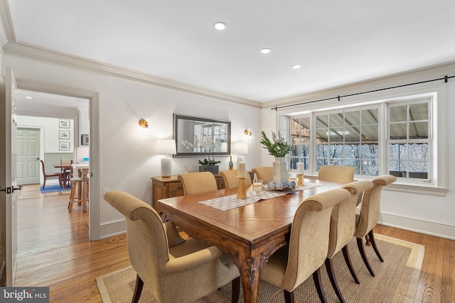 dining space featuring ornamental molding and light hardwood / wood-style floors