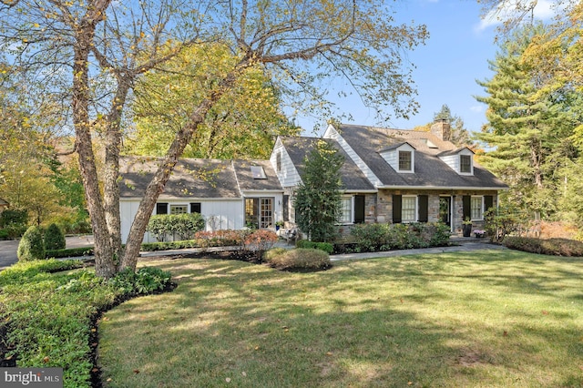 cape cod home with a front yard