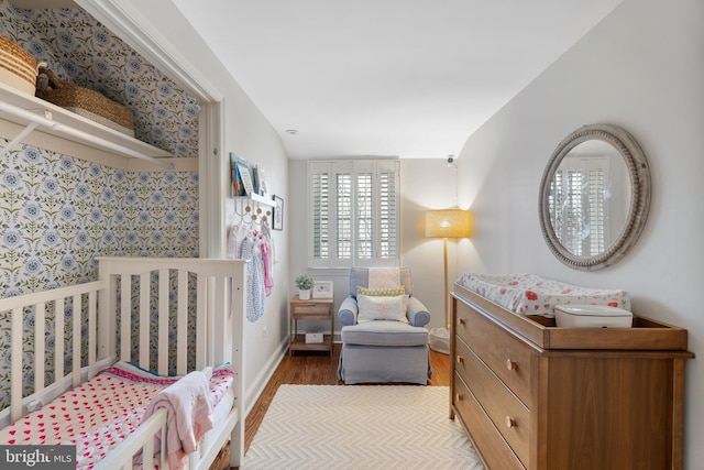 bedroom featuring a crib and hardwood / wood-style flooring