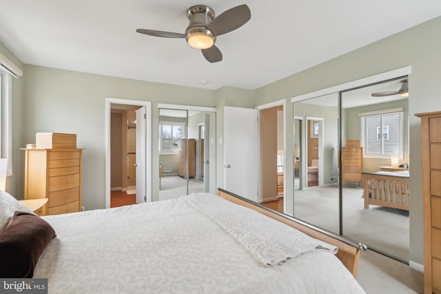 carpeted bedroom with connected bathroom, ceiling fan, and multiple closets