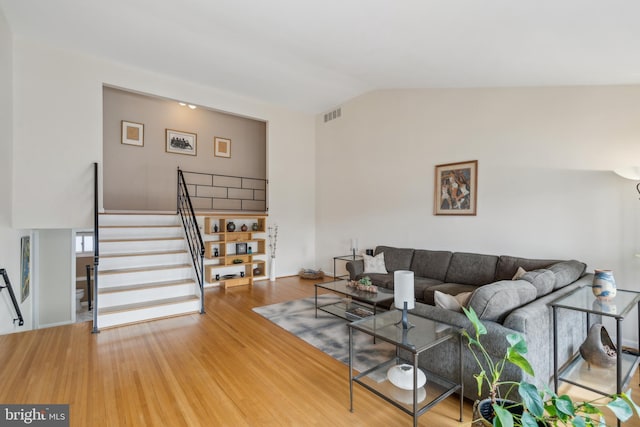 living room featuring vaulted ceiling and hardwood / wood-style floors